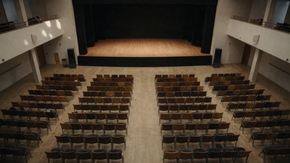 Illustrative image: aerial view of an empty auditorium with rows of seats and a stage