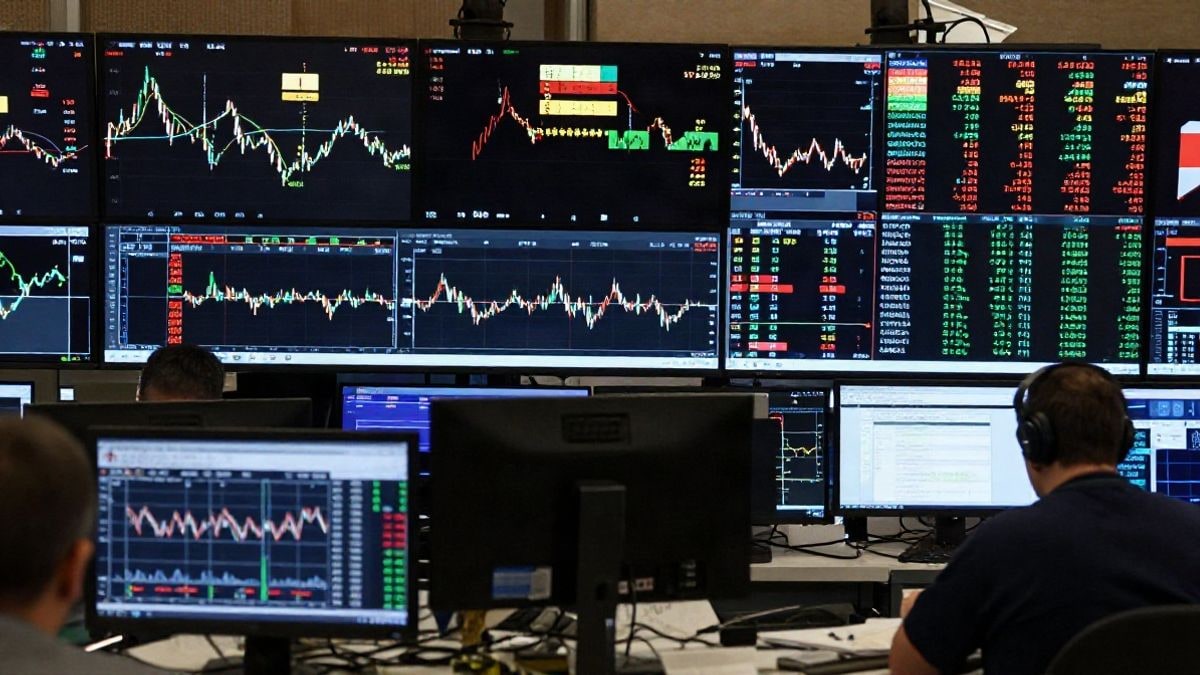 Imagen ilustrativa: vista lateral de un entorno de mercado financiero con pantallas que muestran gráficos fluctuantes y datos económicos.