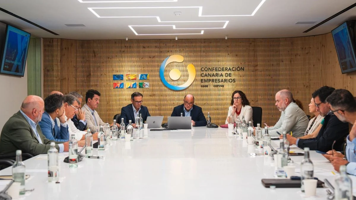 Imagen ilustrativa: sala de reuniones vacía con mesa larga y ventanales, luz natural, ambiente corporativo.
