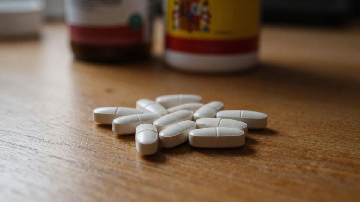 Illustrative image: bottles of supplements on a wooden table with soft side lighting