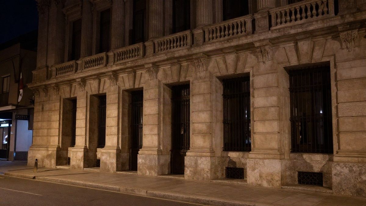 Illustrative image: facade of a judicial building lit by artificial lights in a night setting, with no people present.