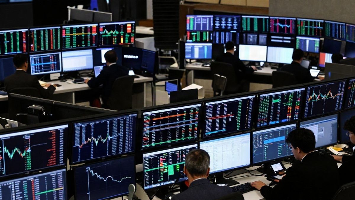 Imagen ilustrativa: vista cenital de un suelo de bolsa con pantallas mostrando datos financieros y gráficos.