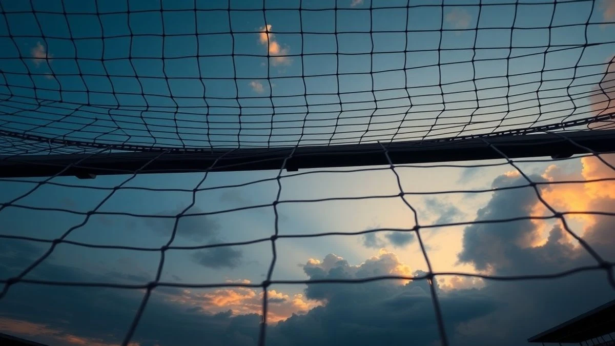 Portería de fútbol con red recortada contra el cielo al atardecer