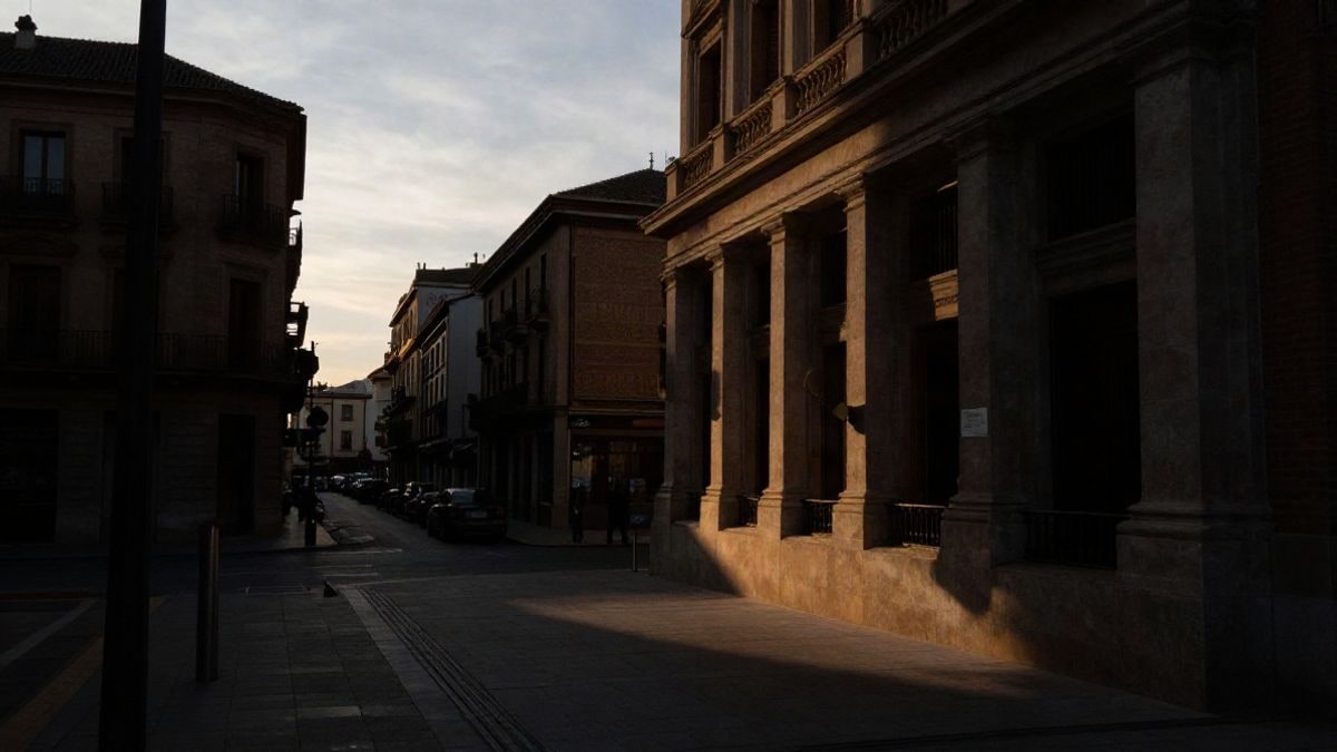 Illustrative image: silhouettes of bank buildings at sunset, with long shadows and dramatic light, financial context.