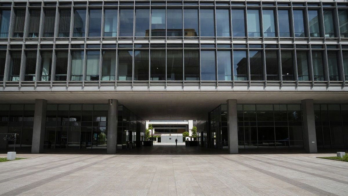 Imagen ilustrativa: un edificio de oficinas moderno con mucho espacio negativo y una figura pequeña en la distancia para simbolizar la actividad de inversión.