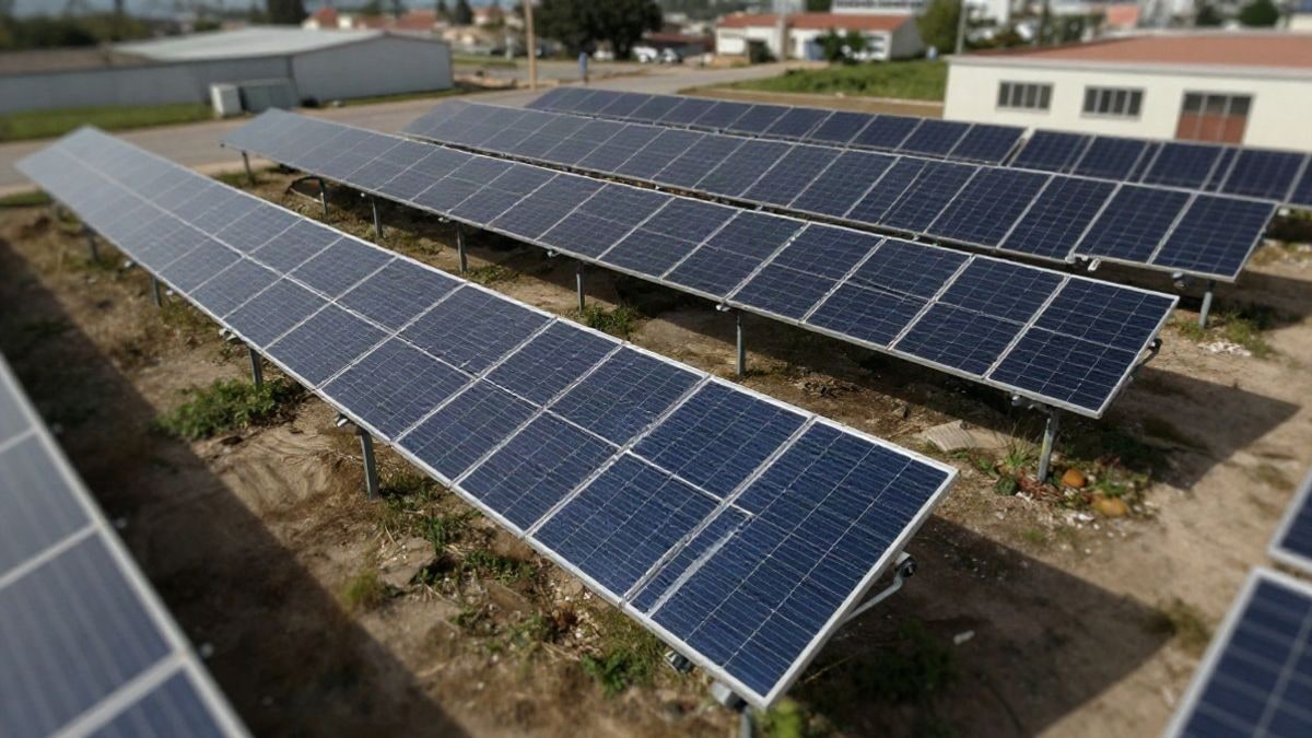 Illustrative image: aerial view of a solar panel installation in an industrial area, representing renewable energy initiatives.