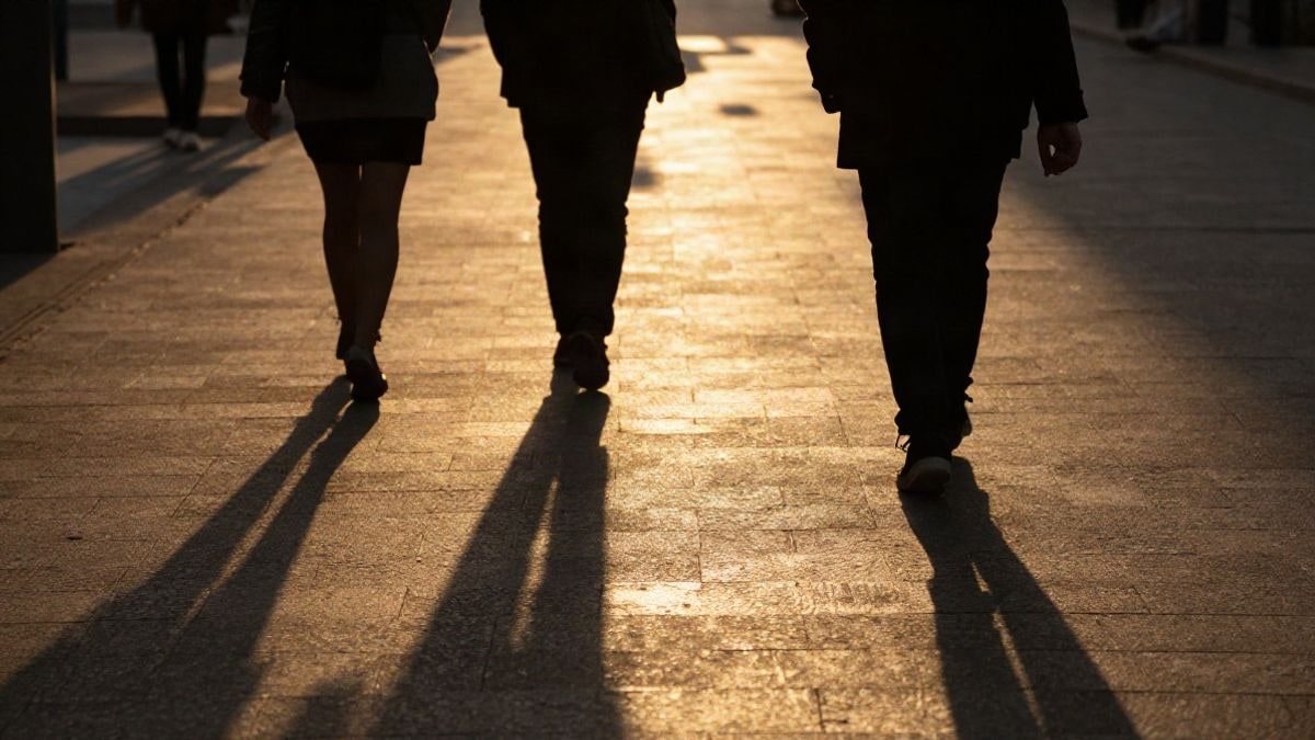 Illustrative image: silhouettes at sunset representing the concept of financial markets with long shadows.