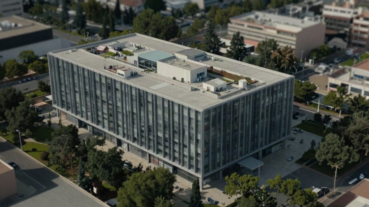 Imagen ilustrativa: vista aérea de un moderno edificio de data center rodeado de vegetación, representando tecnología e infraestructura.