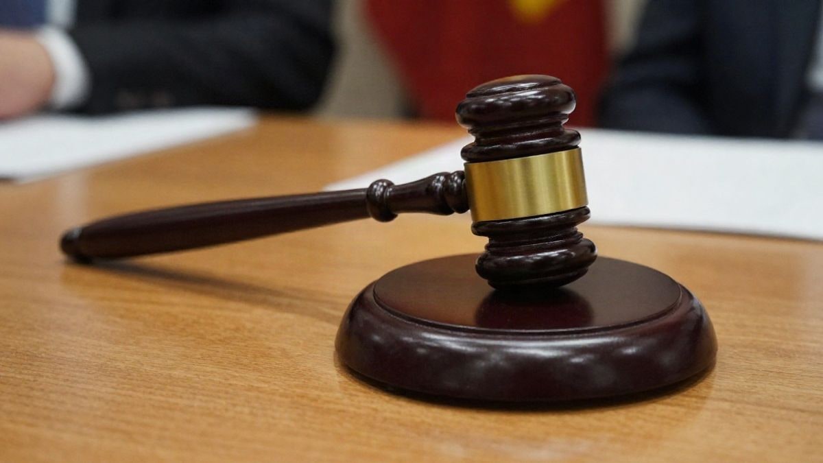 Illustrative image: a close-up of a gavel on a wooden desk, in a dramatic natural light setting.