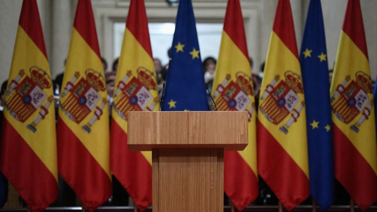 Illustrative image: an empty podium with flags in the background, symbolising a diplomatic event without visible attendees.