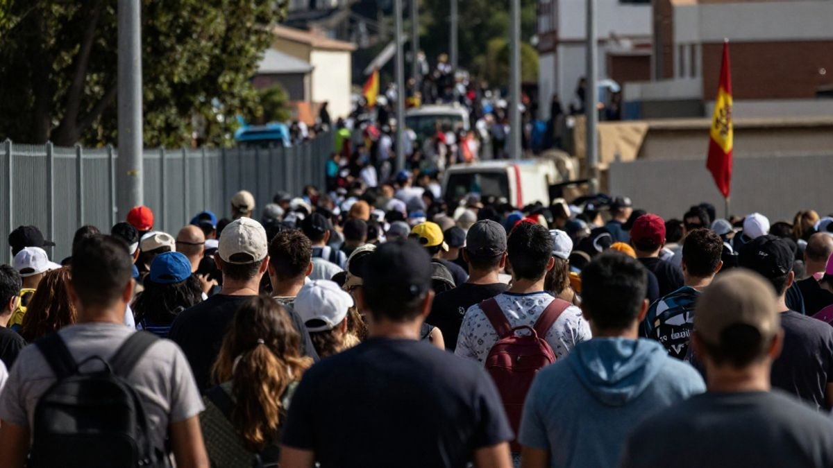 Illustrative image: a view of a crowded border area illustrating the immigration crisis, with a dramatic natural light atmosphere.